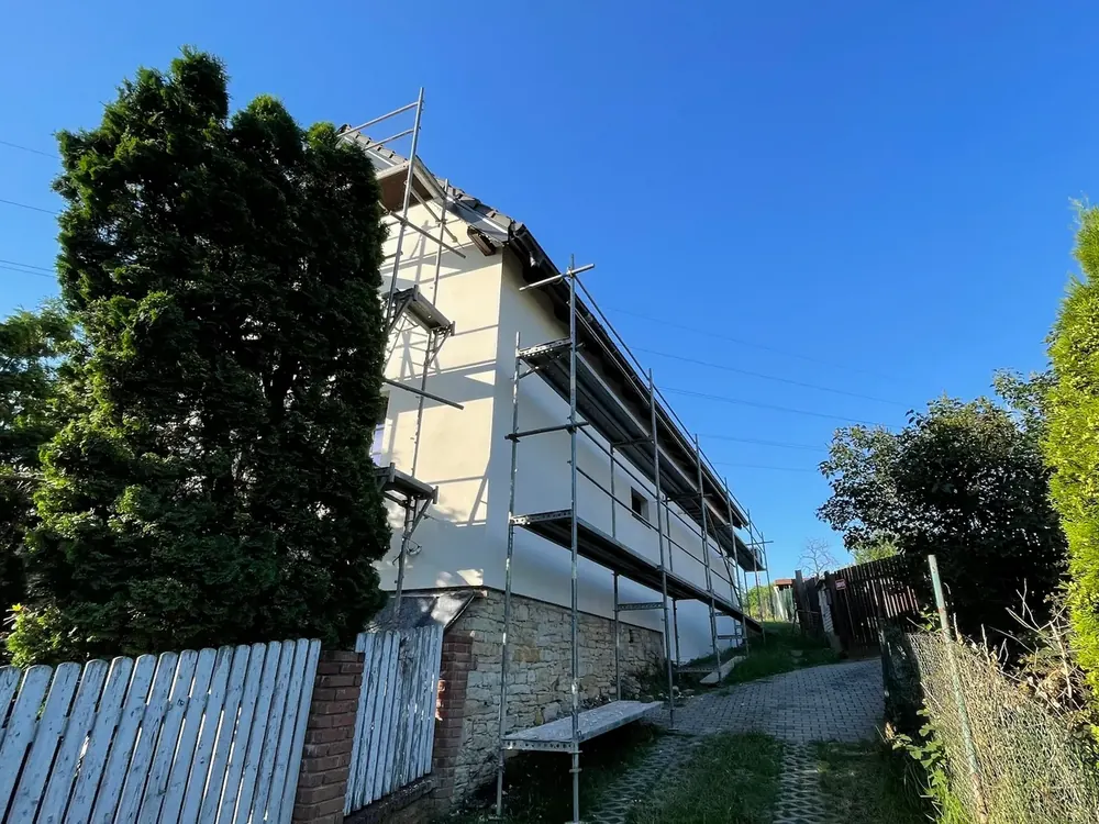 Rodinný dům v lešení při revitalizaci, nová fasáda a odkrytá střecha